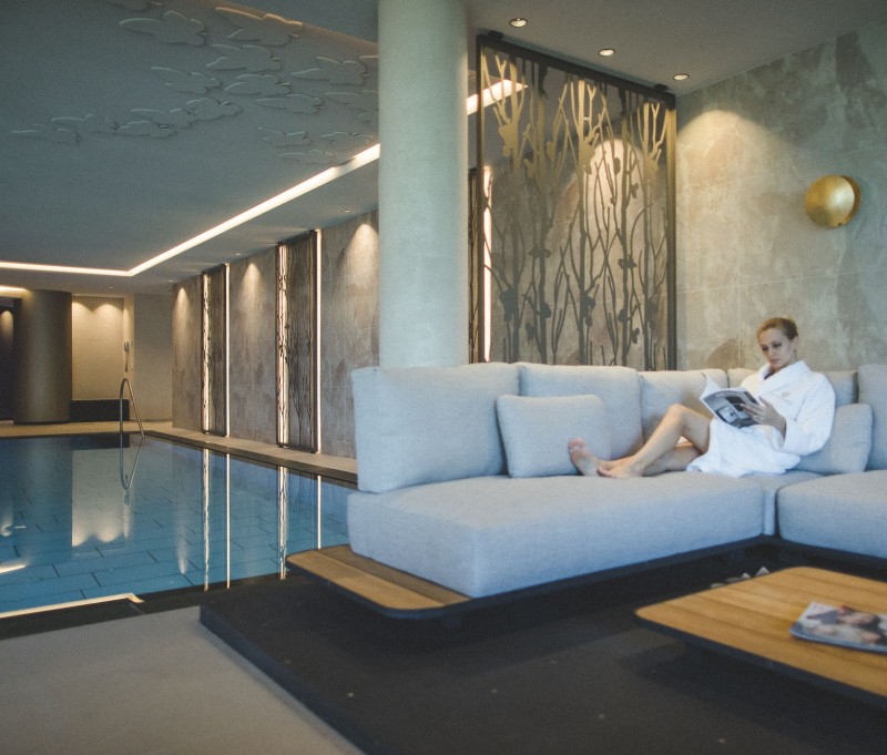 Frau mit Lektüre beim entspannen im Spa Bereich des 4 Sterne S Wellnesshotel Sonnbichl in Dorf Tirol bei Meran